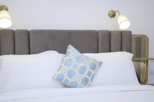 a bed with two white pillows and two lights at Zemilo Hotel Apartment in Addis Ababa