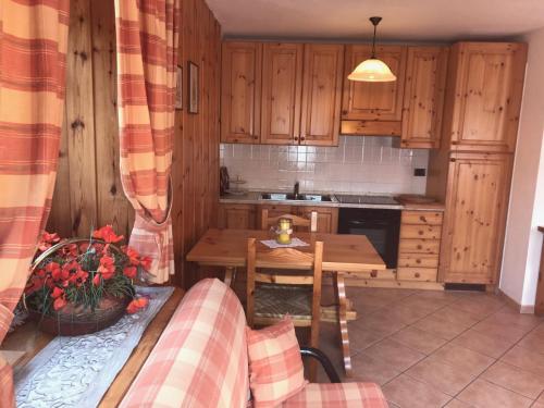 a kitchen with wooden cabinets and a wooden table at Appartamento Monte Rosa in Champoluc