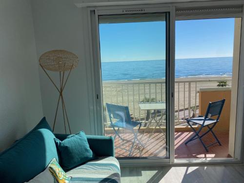 un salon avec un canapé et une vue sur l'océan dans l'établissement BLEU MER Superbe appartement - Vue mer- Climatisé, à Canet