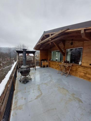 a large outdoor patio with a grill on a house at Casa Zaharia Azuga in Azuga