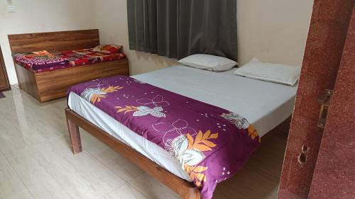 a bedroom with a bed with a purple blanket at The Royal Ascot Holiday Home in Alibaug