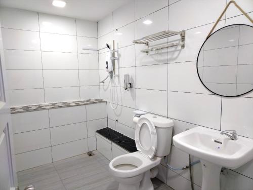 a white bathroom with a toilet and a sink at Greenery Studio, Kubot a Sentral in Tawau