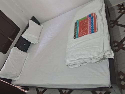 uma cama branca com duas almofadas em cima em PARK AVENUE GUEST HOUSE SULTANPUR em Sultānpur