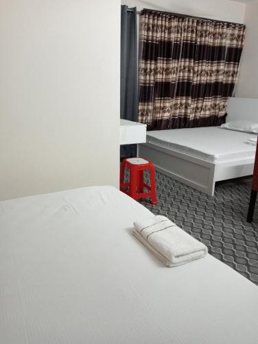 a bedroom with two beds and a towel on the bed at Hotel In Need - Near to the US France Italy Saudi Embassy and Airport in Dhaka