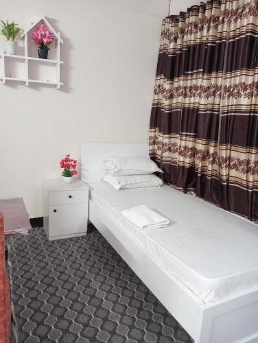 a room with a bed and a curtain at Hotel In Need - Near to the US France Italy Saudi Embassy and Airport in Dhaka