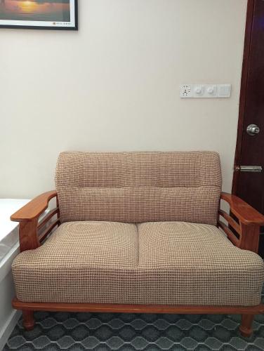 a couch sitting in the corner of a room at Hotel In Need - Near to the US France Italy Saudi Embassy and Airport in Dhaka