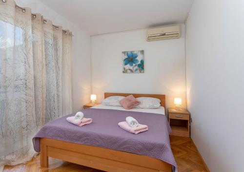 - une chambre avec un lit et des serviettes roses dans l'établissement Stunning sea view apartment Ani, à Hvar