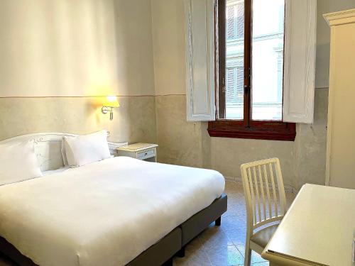 フィレンツェにあるホテル ドゥーカ ダオスタのベッドルーム1室(ベッド1台、テーブル、窓付)
