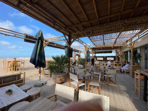 un restaurant sur la plage avec tables et chaises dans l'établissement Sea and sun, à Saint-Jean-de-Monts