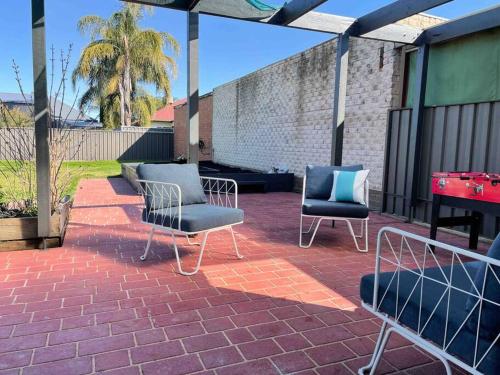 - 2 chaises et une table sur une terrasse en briques dans l'établissement 83 Appin - Newly renovated house, à Wangaratta