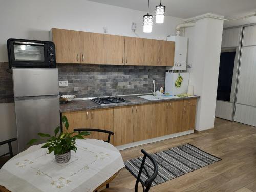 eine Küche mit Tisch, Spüle und Herd in der Unterkunft Casa Ioana in Târgu Mureș