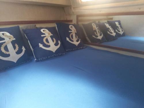 1 cama con almohadas azules y una representación de un barco en Barco acogedor en el puerto del másnou, en Masnou