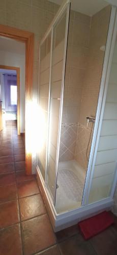 a glass shower in a bathroom with a light at La Higuera de Gredos in Higuera de las Dueñas