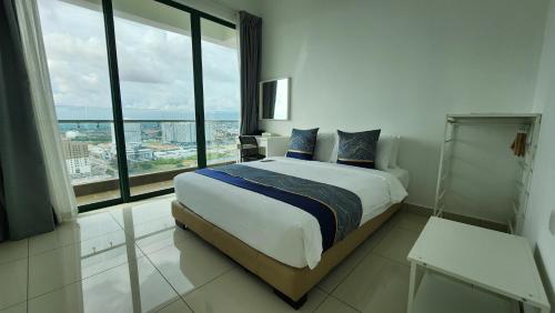 a bedroom with a large bed and a large window at The Suites SGR Melaka in Melaka