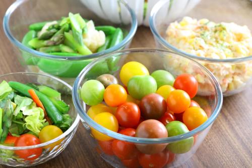 four glass bowls filled with fruits and vegetables on a table at Dormy Inn Premium Ginza - Natural Hot Spring in Tokyo