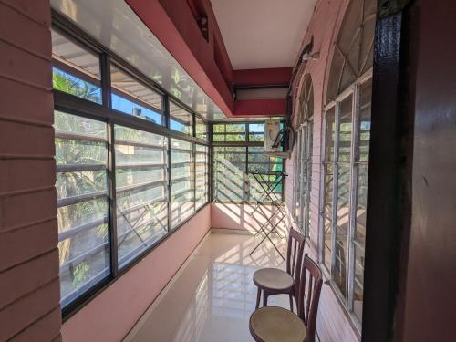 a room with two chairs and large windows at Saikia Nest the Home-stay in Guwahati