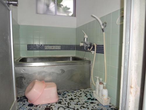 a bathroom with a tub and a pink toilet at Tentsuku Guest House in Tanabe