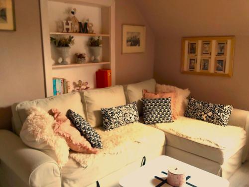 a living room with a white couch with pillows at InGreen house in Bohinjska Bela