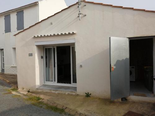 un bâtiment blanc avec une grande porte sur son côté dans l'établissement Joli studio au calme, à Grand-Village-Plage