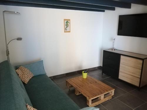- un salon avec un canapé vert et une table basse dans l'établissement Joli studio au calme, à Grand-Village-Plage
