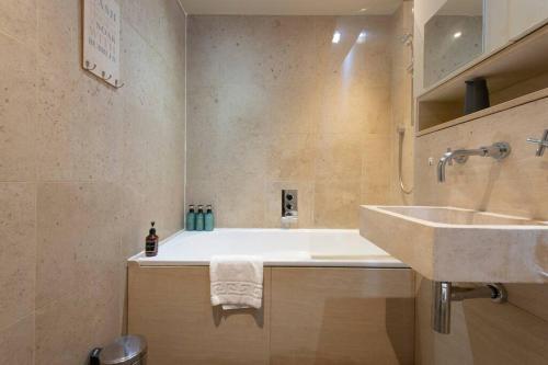 a bathroom with a sink and a bath tub at Elegant 1-BR Retreat in Ilford Centre in Ilford