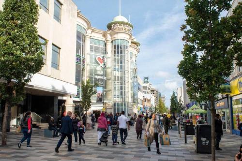 a group of people walking down a street in a city at Elegant 1-BR Retreat in Ilford Centre in Ilford