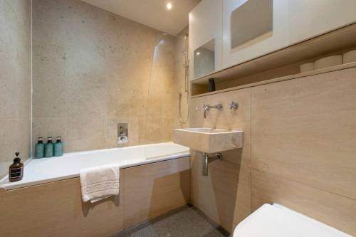a bathroom with a sink and a bath tub at Elegant 1-BR Retreat in Ilford Centre in Ilford