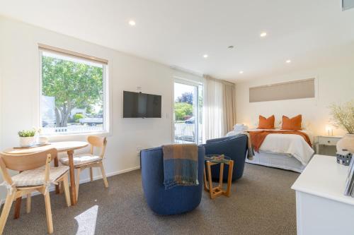 a bedroom with a bed and a table and chairs at The Mayflower Cottage in Te Anau
