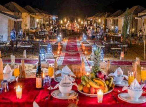 Merzouga Top Luxury Camp في مرزوقة: طاولة عليها صحون من الفواكه