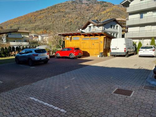 a parking lot with cars parked in front of a building at Ca Giardina in Levico Terme