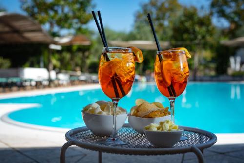 two glasses of food on a table next to a pool at Hotel Villa Rizzo Resort and Spa in San Cipriano Picentino