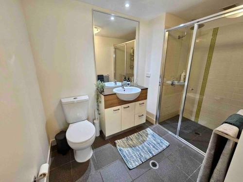 a bathroom with a toilet and a sink and a shower at Luxury City Center King Bed Apartment and Study in Brisbane
