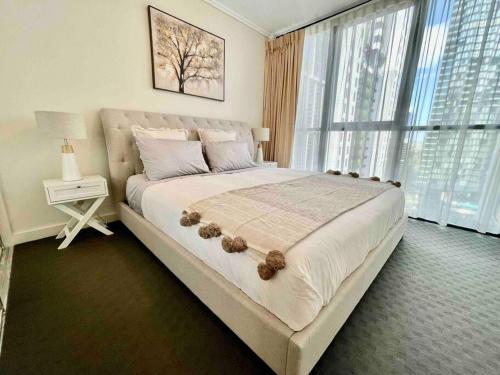 a bedroom with a large bed with a large window at Luxury City Center King Bed Apartment and Study in Brisbane