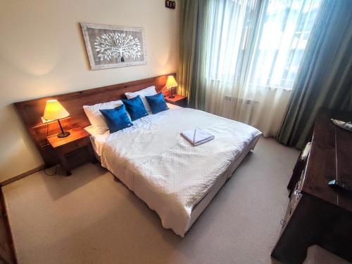 um quarto com uma cama grande e almofadas azuis em Private 1bedroom apartment in SPA Resort em Bansko