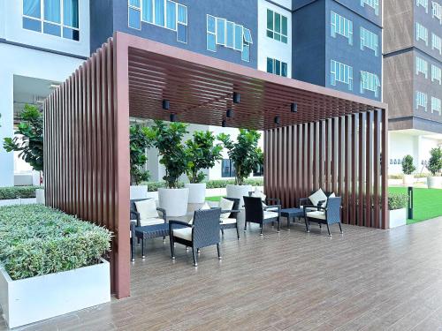 un patio avec des chaises et des tables dans un bâtiment dans l'établissement Amber Cove by C Homestay Malacca, à Malacca