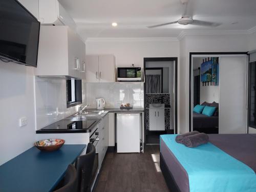 una cocina con armarios blancos y una cama azul. en The Dugongs' Rest en Horn