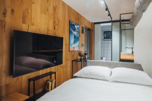 a bedroom with a bed with a television on the wall at City Glamping by ONE66 Hotel in Ljubljana