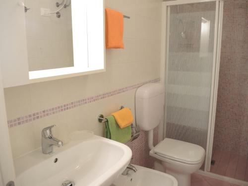 ein Bad mit einem Waschbecken, einem WC und einer Dusche in der Unterkunft Luminous and cozy 1 bedroom apartment with sea view in Bibione