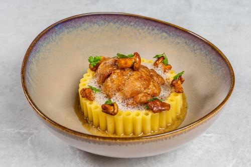 a bowl of food with a chicken on pasta at Château De Noirieux in Briollay