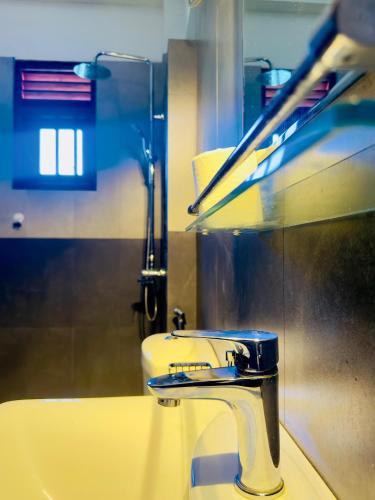 a bathroom with a sink and a faucet at Halcyon Rest in Hikkaduwa