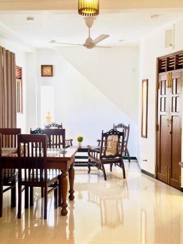 a dining room with a table and chairs and a ceiling at Halcyon Rest in Hikkaduwa