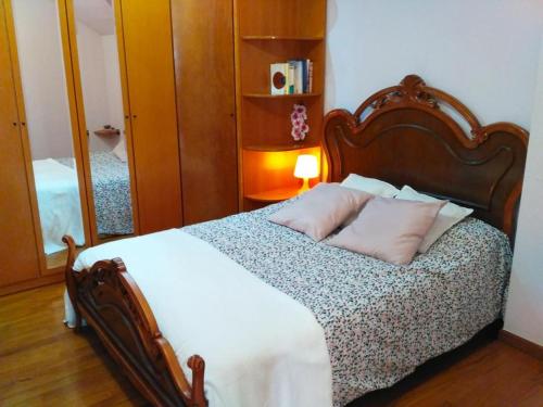 a bedroom with a bed with two pillows and a mirror at Ático cerca de la playa in Castro-Urdiales