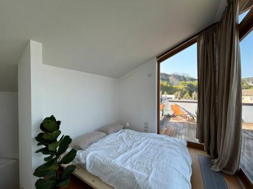 a bedroom with a bed and a large window at Casa Alegría in Trento