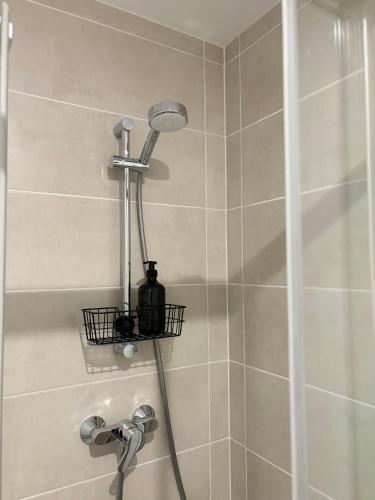 une douche avec pommeau de douche dans une salle de bain dans l'établissement Studio en centre ville + wifi, à Labruguière