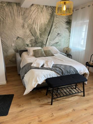 ein Schlafzimmer mit einem großen Bett mit Wandbild in der Unterkunft Studio en centre ville + wifi in Labruguière