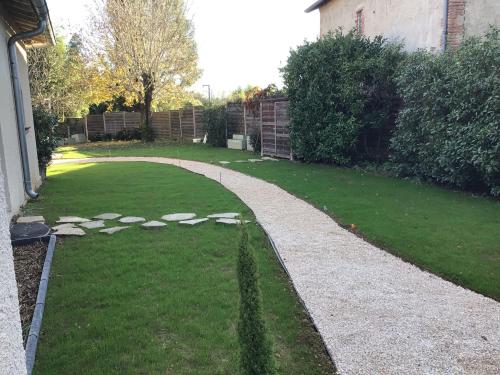 a garden with a stone path in the grass at Les berges du Seudo in Labastide-de-Lévis