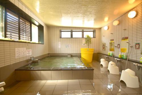 a large bathroom with a tub and toilets in it at OUTDOOR STYLE AMIDA in Shōgahora