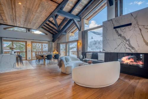 a living room with a fireplace and a table with chairs at Les Chalets de La Clusaz - Appartement le Renne in La Clusaz