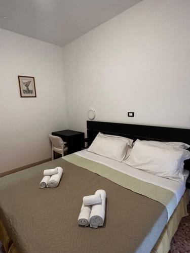 una camera da letto con un letto e due asciugamani di Hotel Perla a Cesenatico