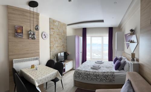 a bedroom with a bed and a table and a couch at Apartman Vana in Kopaonik